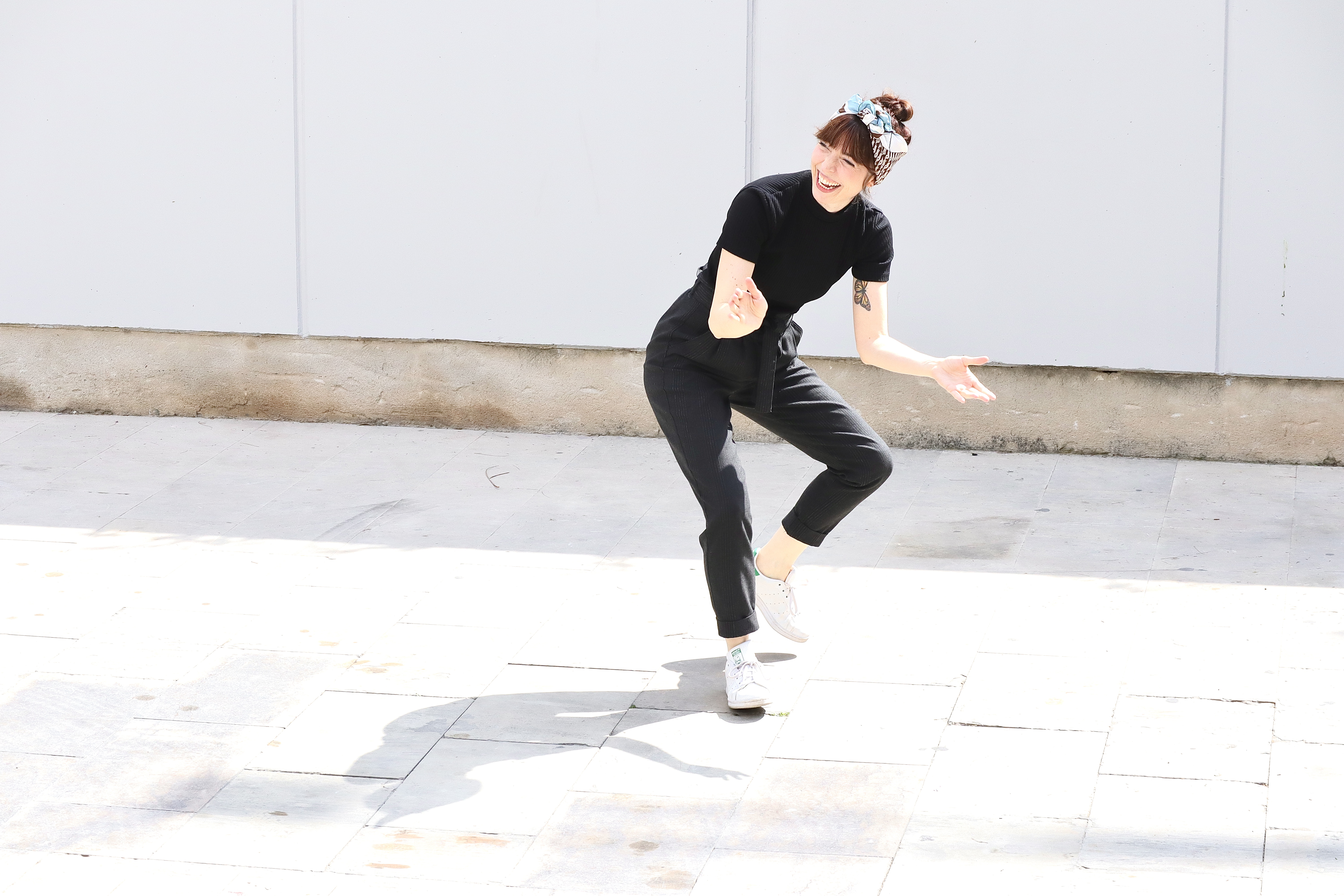 Solo swing dancer smiling mid-step outdoors